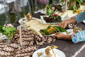 Malay style wedding catering with elegant gold table decorations and candles by idocatering